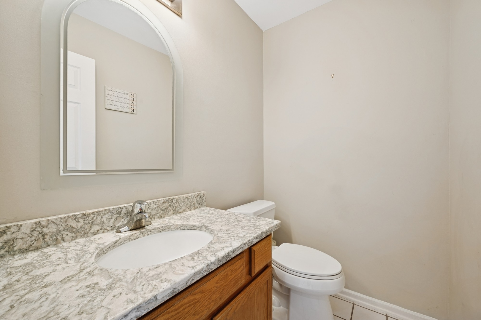 1005 Honeysuckle Drive Wheeling, IL 60090 - Photo 5 of 25 a bathroom with a granite countertop toilet a sink and a mirror