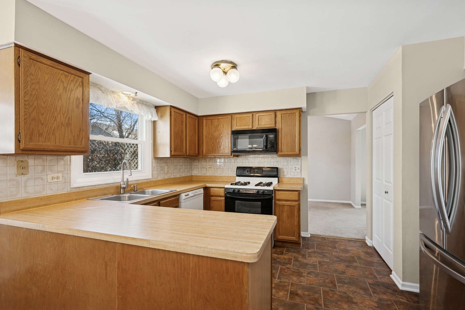 1005 Honeysuckle Drive Wheeling, IL 60090 - Photo 6 of 25 a kitchen with stainless steel appliances a stove refrigerator sink and microwave
