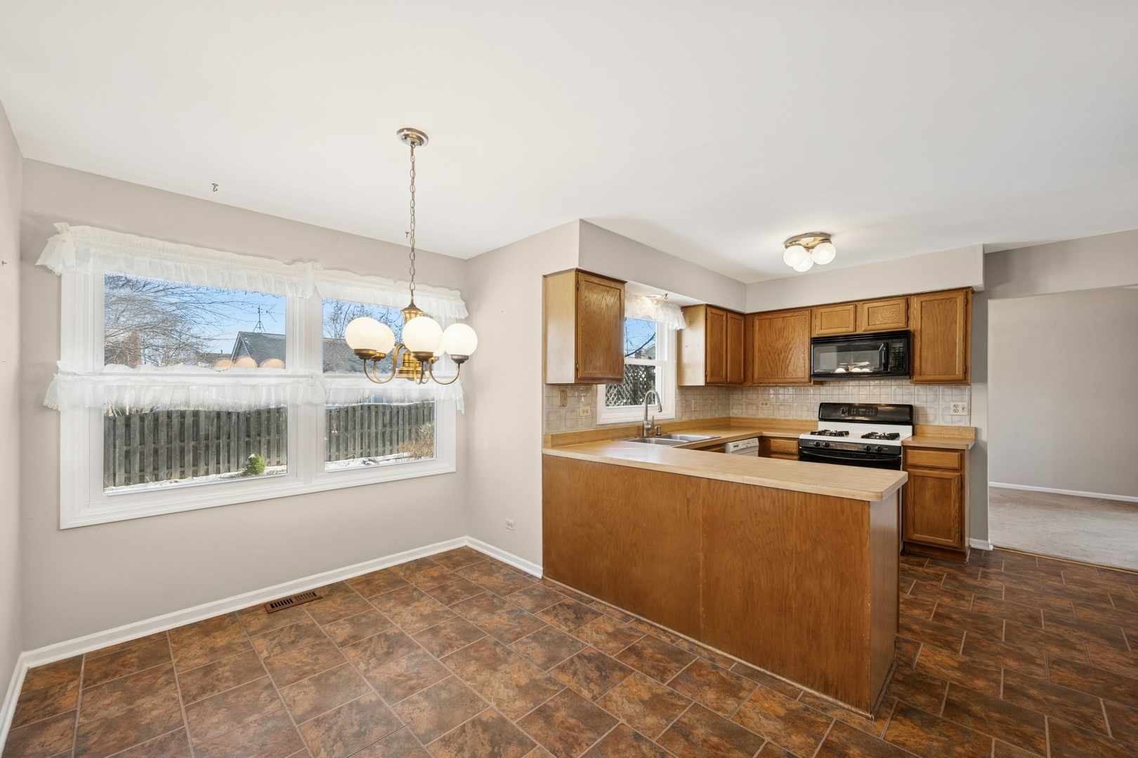 1005 Honeysuckle Drive Wheeling, IL 60090 - Photo 8 of 25 a kitchen with stainless steel appliances granite countertop a stove top oven a sink dishwasher a refrigerator and a dining table with wooden floor