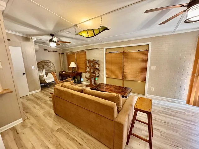 a living room with furniture a flat screen tv and a floor to ceiling window
