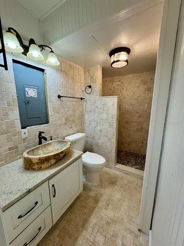 a bathroom with a granite countertop sink toilet and shower