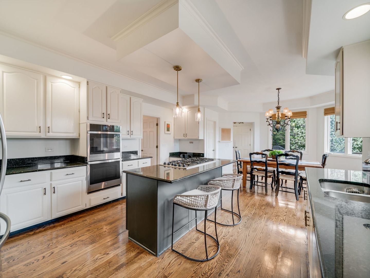 626 Buena Road Lake Forest, IL 60045 - Photo 11 of 37 a kitchen with stainless steel appliances granite countertop a stove top oven a sink a dining table and chairs with wooden floor