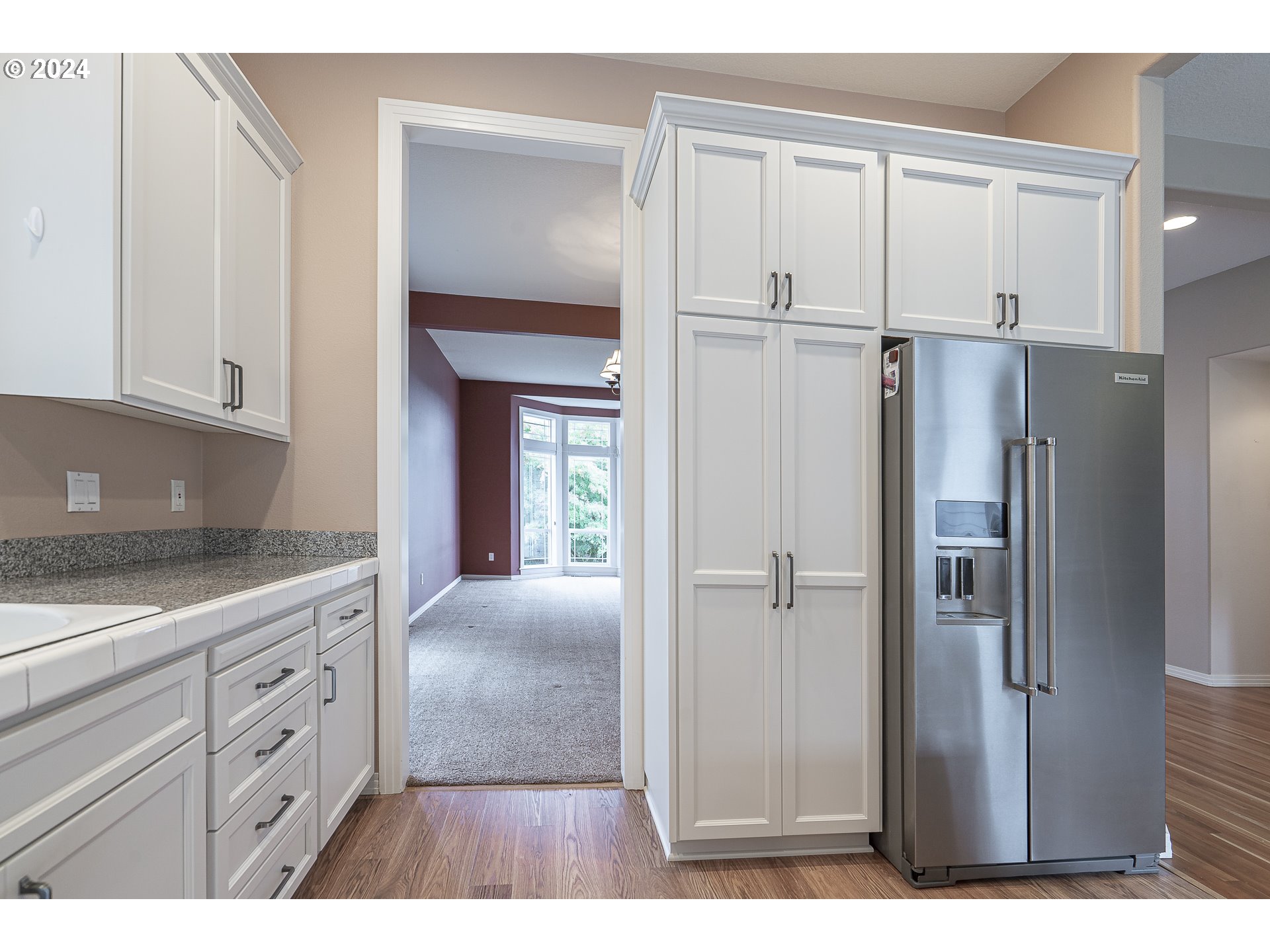 11084 Southeast Valley Way Happy Valley, OR 97086 - Photo 11 of 40 a kitchen with a refrigerator and white cabinets