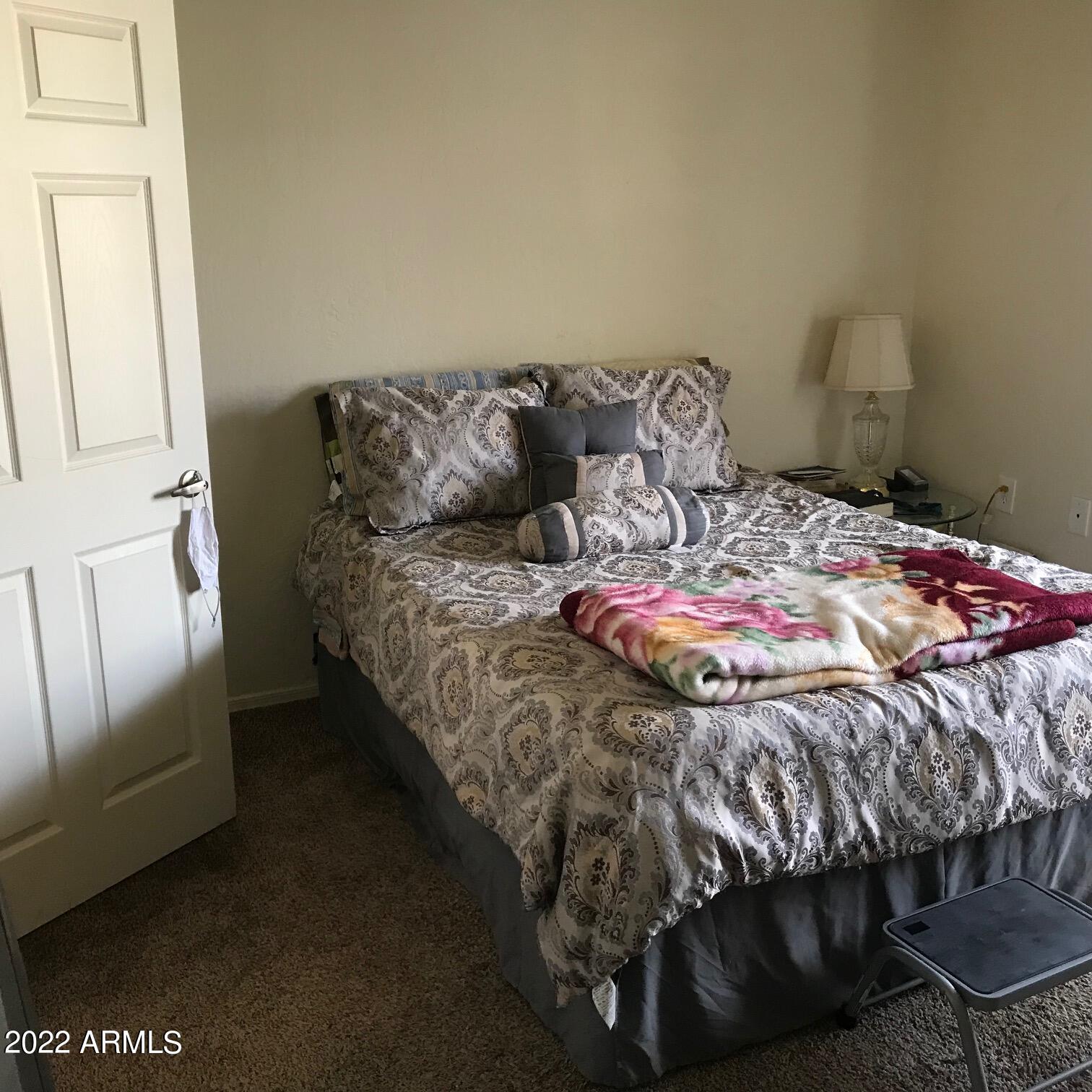 12221 West Bell Road, Unit 370 Surprise, AZ 85378 - Photo 10 of 18 a bedroom with a bed and chair