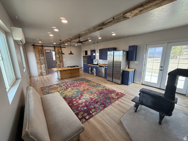 14183 High Mesa Loop Duchesne, UT 84021 - Photo 28 of 56 Living area featuring a barn door, light wood finished floors, recessed lighting, and french doors