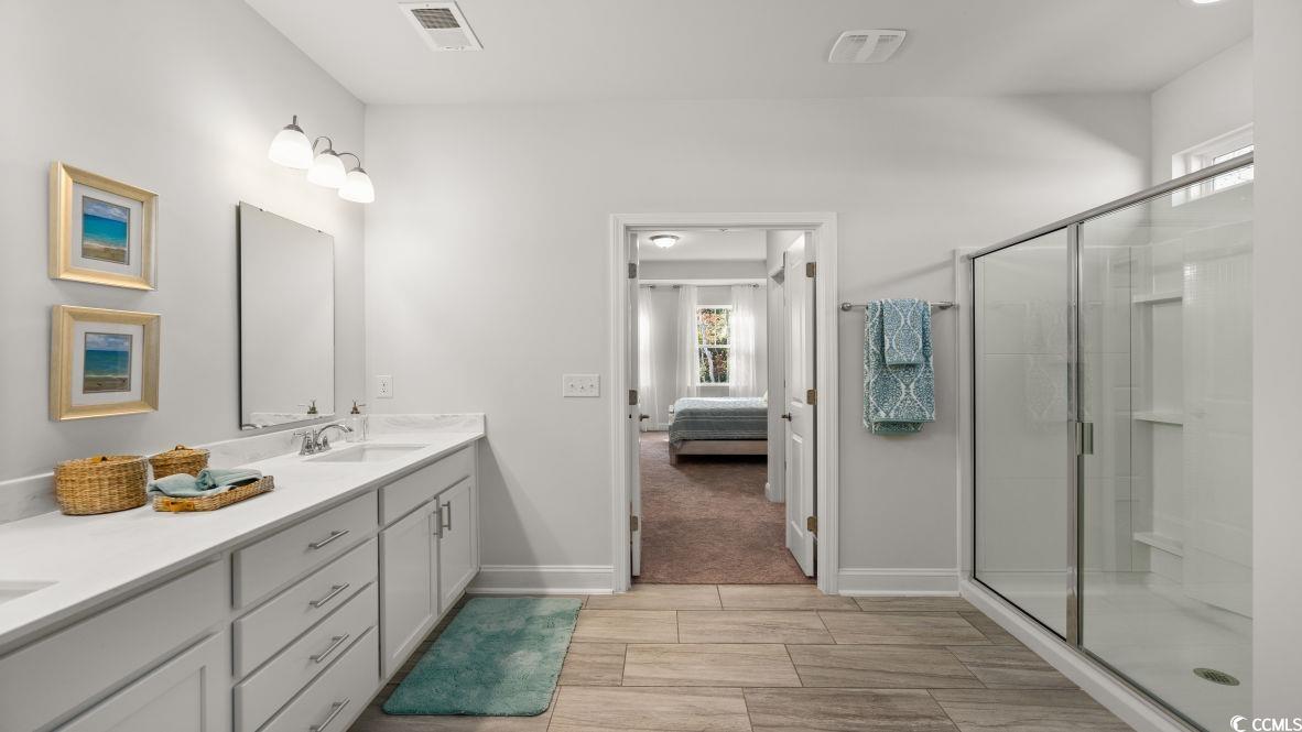 737 Doonbeg Court Conway, SC 29526 - Photo 21 of 33 Ensuite bathroom with double vanity, a shower stall, wood tiled floors, and baseboards