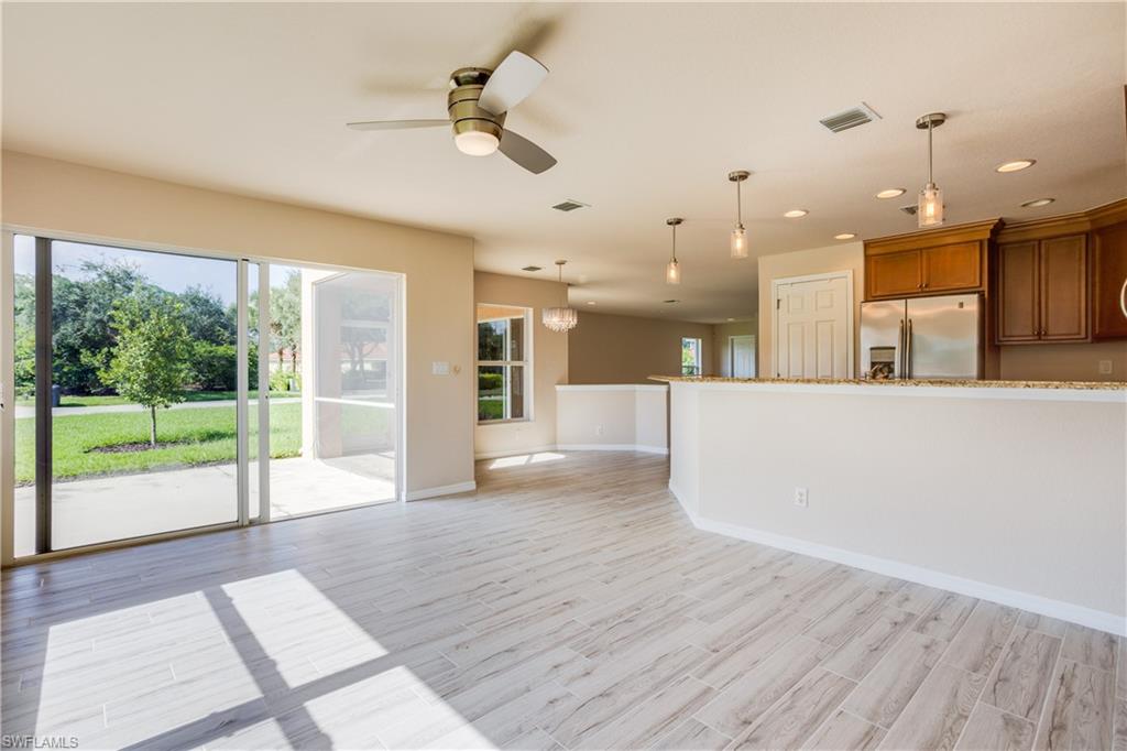 9026 Astonia Way Estero, FL 33967 - Photo 11 of 38 a view of a living room and a kitchen with a floor to ceiling window