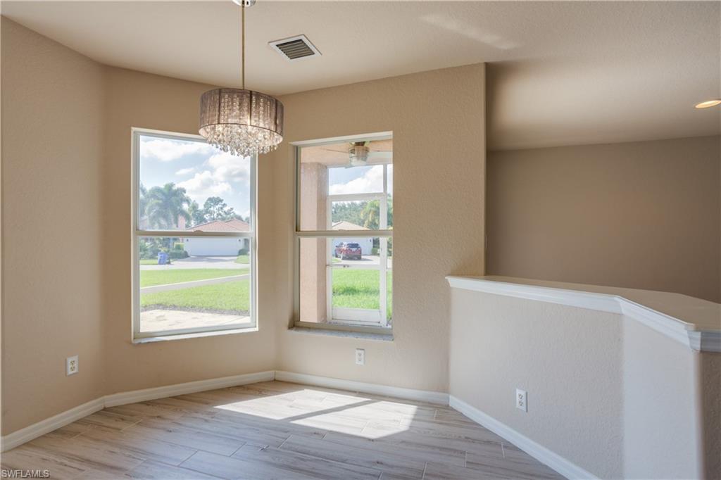 9026 Astonia Way Estero, FL 33967 - Photo 12 of 38 a view of an empty room with wooden floor and windows