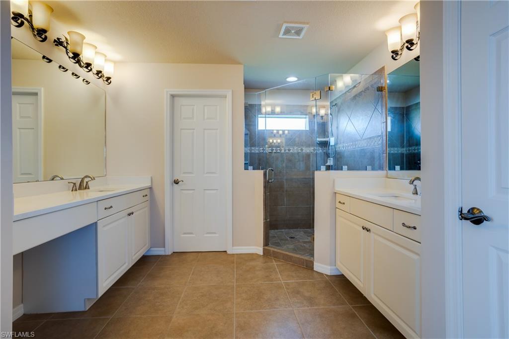 9026 Astonia Way Estero, FL 33967 - Photo 20 of 38 a bathroom with a double vanity sink a toilet a mirror and shower