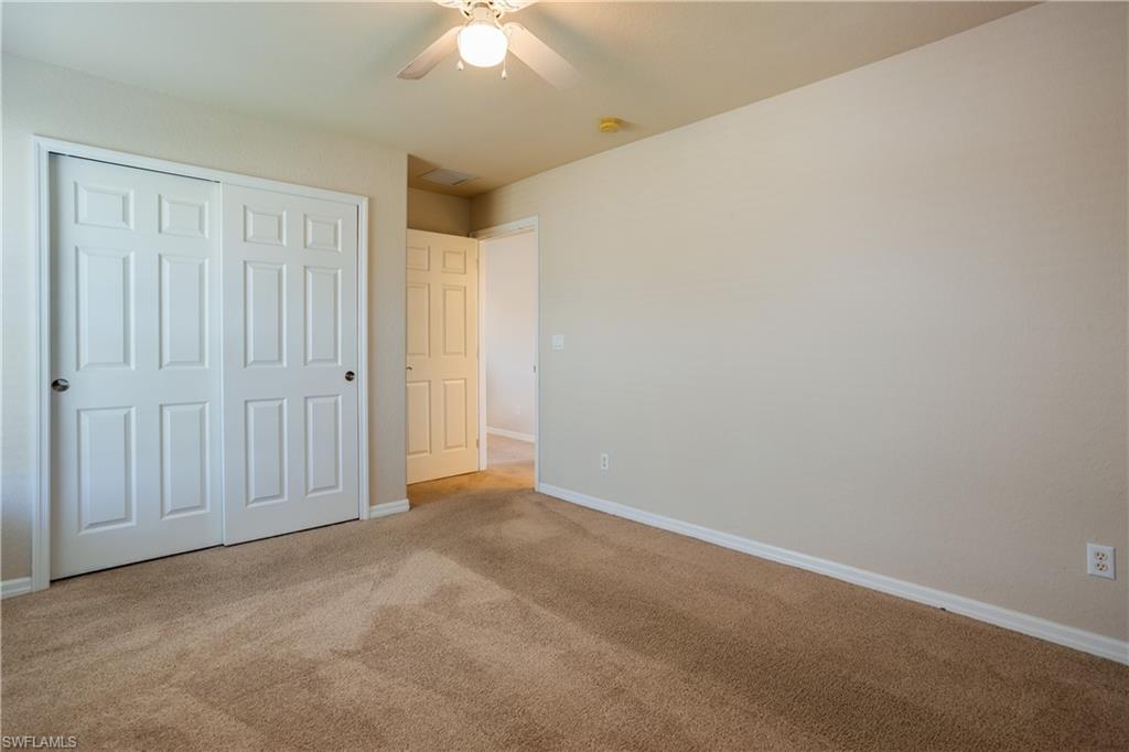 9026 Astonia Way Estero, FL 33967 - Photo 28 of 38 an empty room with a chandelier fan