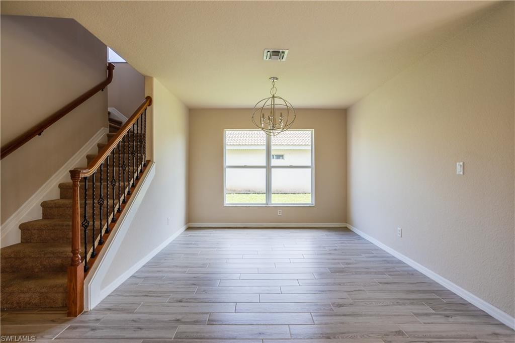 9026 Astonia Way Estero, FL 33967 - Photo 7 of 38 wooden floor in an empty room with a window