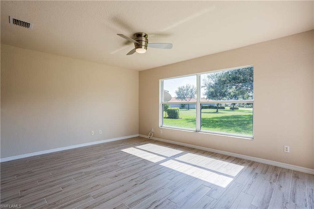 9026 Astonia Way Estero, FL 33967 - Photo 9 of 38 a view of an empty room with wooden floor and a window
