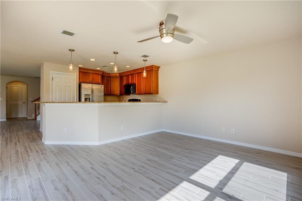 9026 Astonia Way Estero, FL 33967 - Photo 10 of 38 a view of a room with wooden floor and ceiling fan