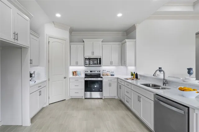 a kitchen with white cabinets and appliances