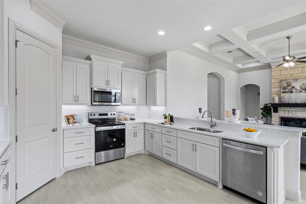 725 Jameson Springtown, TX 76082 - Photo 12 of 38 a kitchen with white cabinets and white appliances