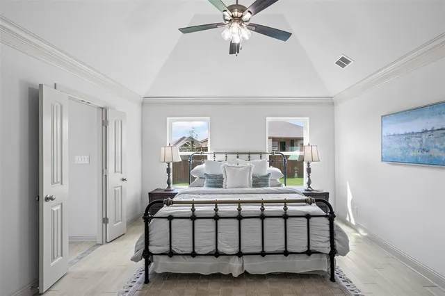 a bedroom with a large bed and a chandelier