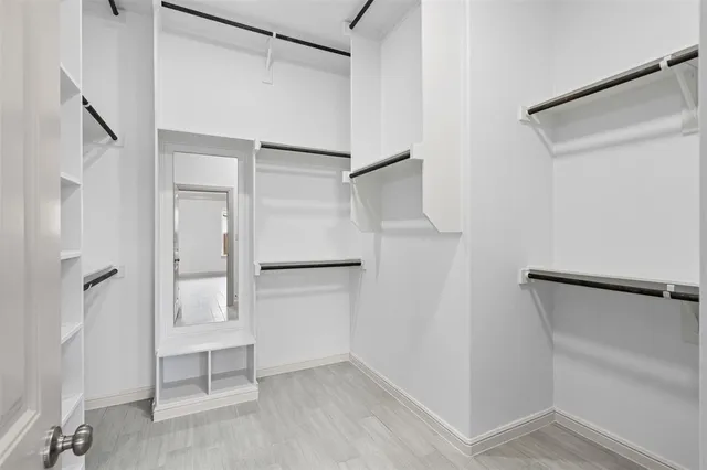 a view of walk in closet with empty racks