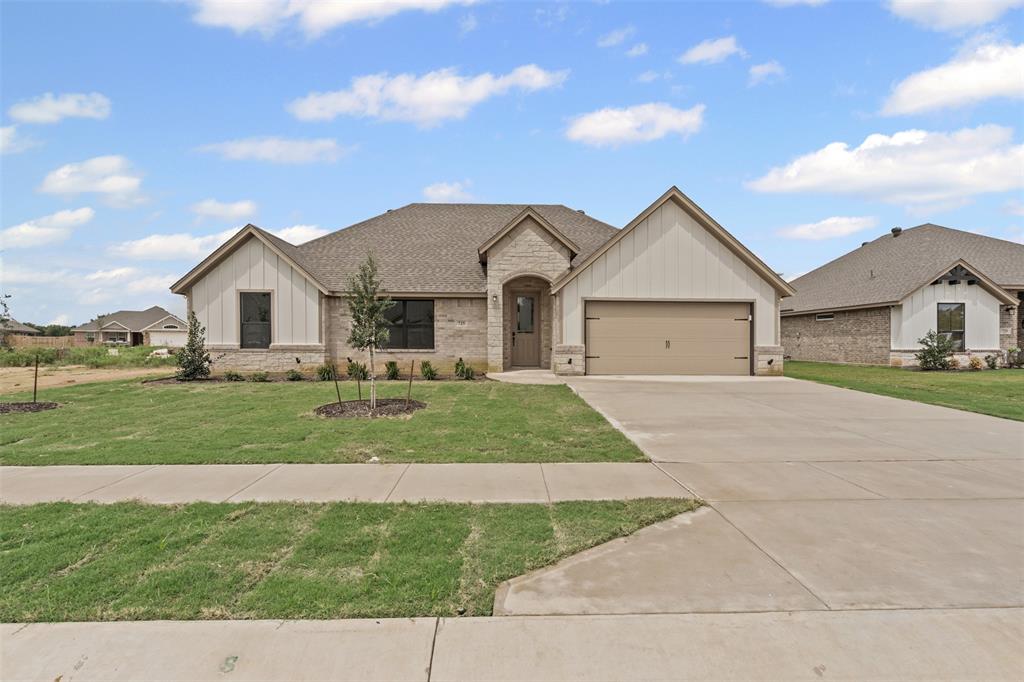 725 Jameson Springtown, TX 76082 - Photo 4 of 38 a front view of a house with a garden and yard