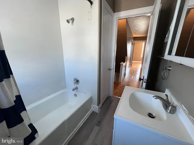 a bathroom with a tub sink and mirror