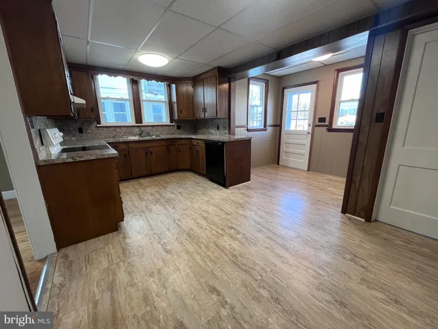 a kitchen with stainless steel appliances granite countertop a sink a stove and a wooden floors