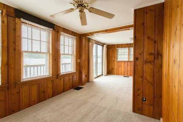 a view of a livingroom with a chandelier fan and wooden floor