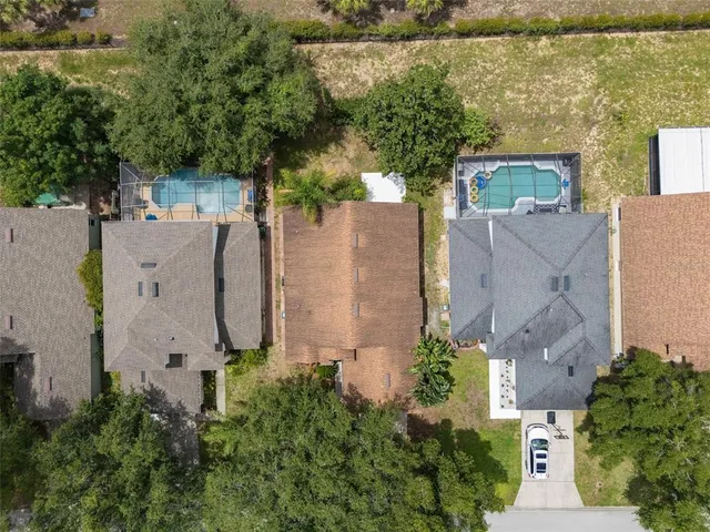 an aerial view of residential houses with outdoor space and trees