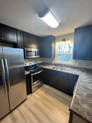 a kitchen with granite countertop stainless steel appliances and wooden cabinets