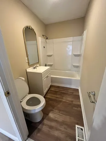 a white toilet sitting next to a bath tub