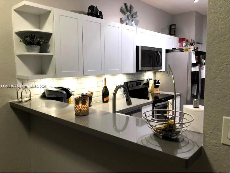 4913 Southwest 141st Avenue, Unit 2 Miramar, FL 33027 - Photo 7 of 12 a kitchen with a sink a stove and cabinets