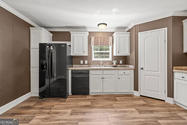 a kitchen with granite countertop a refrigerator cabinets and wooden floor