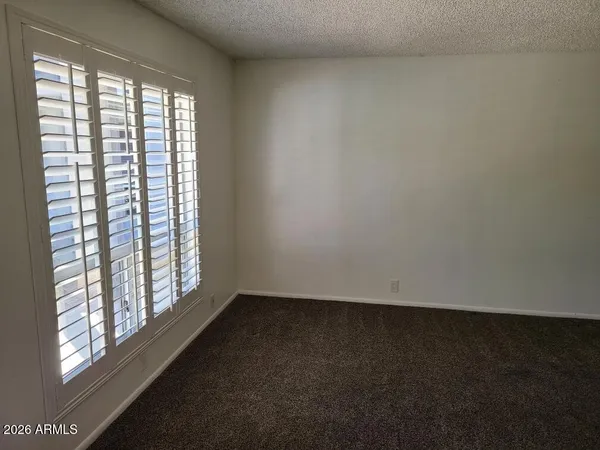 an empty room with windows and cabinet