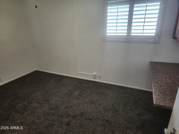 an empty room with a ceiling fan and a window