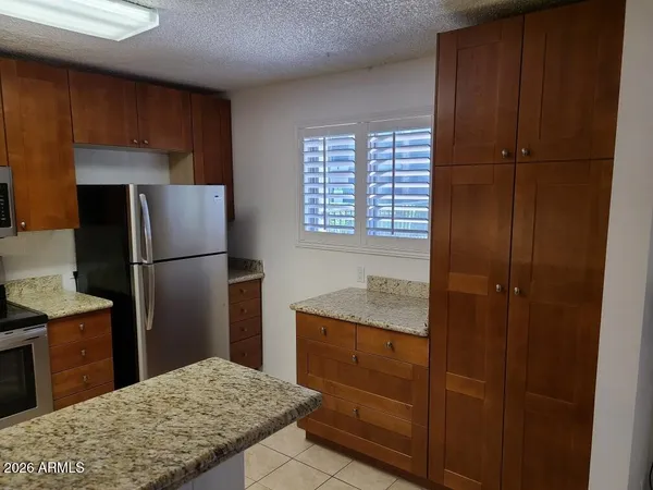 a kitchen with granite countertop wood cabinets and a stove