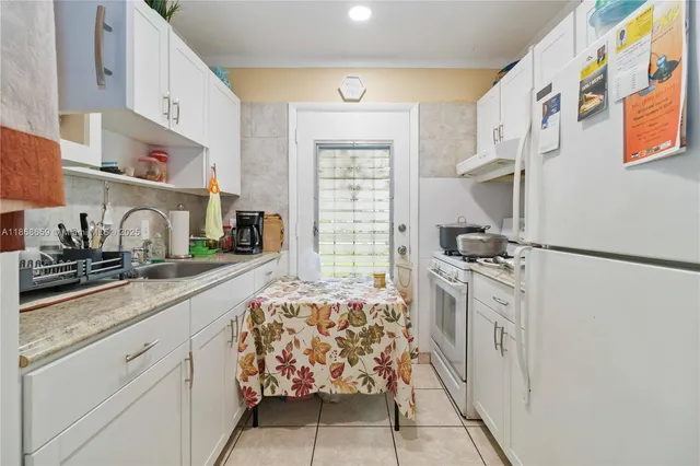 a kitchen with stainless steel appliances granite countertop a lot of cabinets and wooden floor
