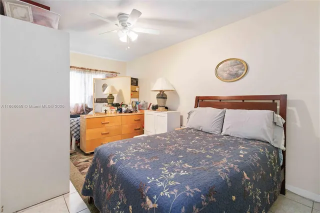 a bed sitting in a bedroom next to a window and a chandelier