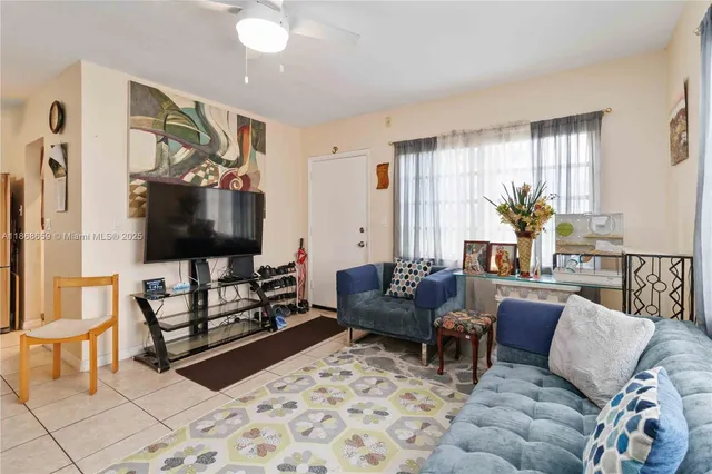 a living room with furniture a flat screen tv and a window