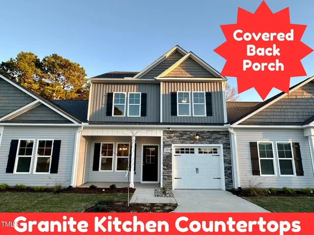 a view of a brick house with windows and a yard