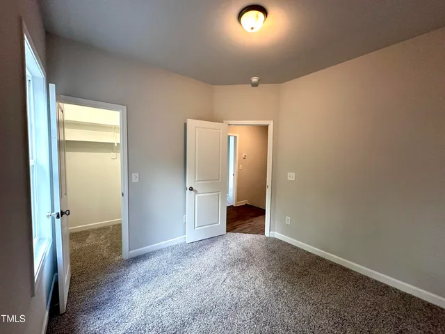 an empty room with closet and a bathroom