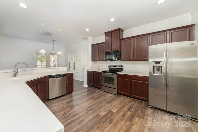 a kitchen with stainless steel appliances kitchen island granite countertop a refrigerator stove and sink