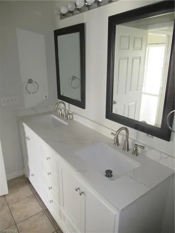 a bathroom with a double vanity sink and a mirror