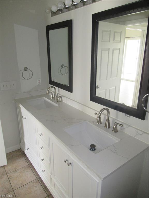 7965 Preserve Circle, Unit 732 Naples, FL 34119 - Photo 14 of 28 a bathroom with a double vanity sink and a mirror