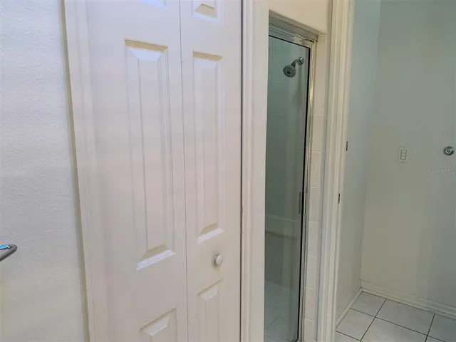 a view of an empty room and window and chandelier fan