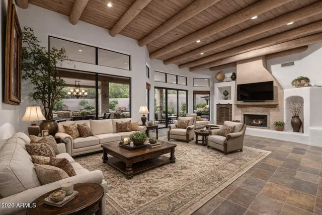 a spacious bedroom with a bed a dresser and a chandelier