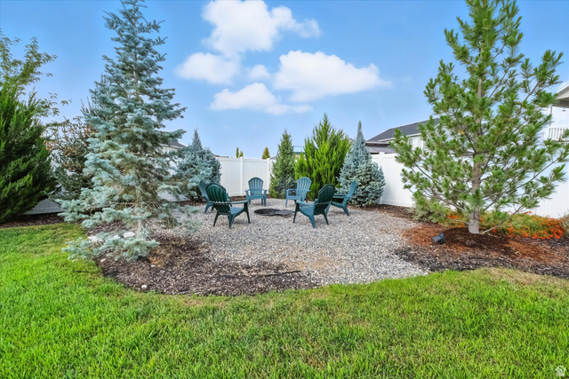 1055 West 2500th Street South Logan, UT 84321 - Photo 37 of 53 Gravel patio area featuring a built-in fire pit, surrounded by a white privacy fence