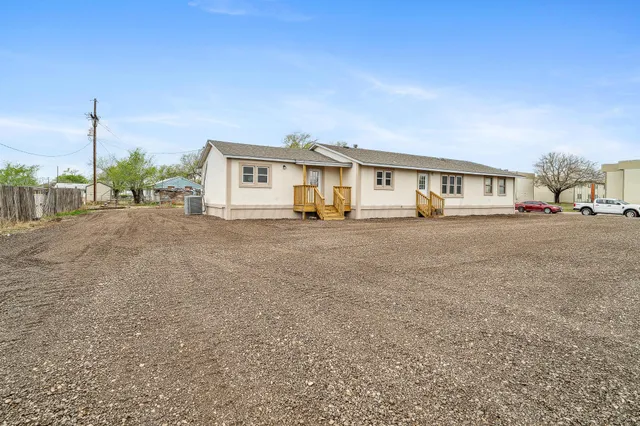 a view of a house with a big yard and large trees