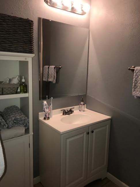 4117 33rd Street Lubbock, TX 79410 - Photo 9 of 14 a bathroom with a sink and a mirror