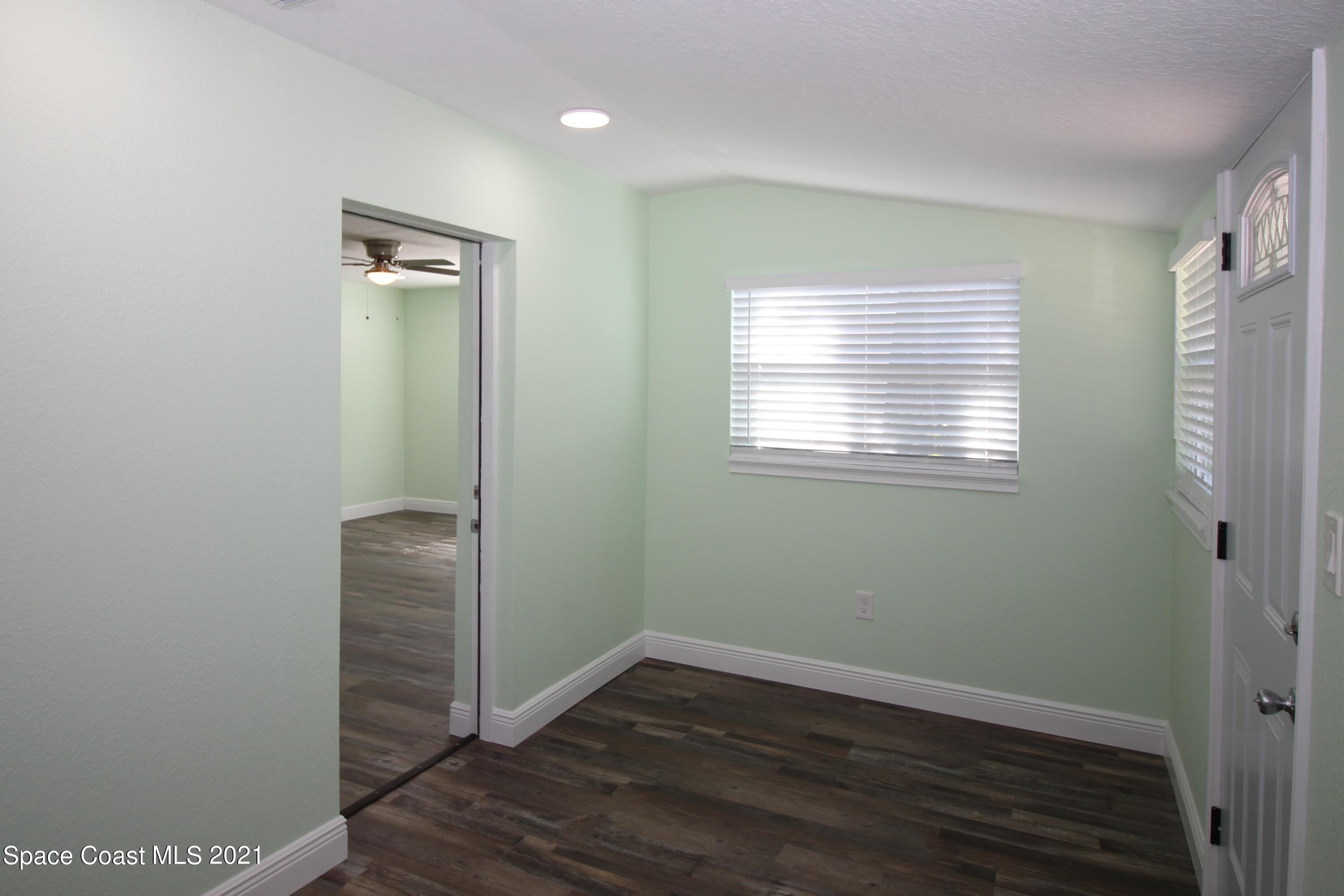 244 North Grove Street Merritt Island, FL 32953 - Photo 19 of 25 a view of an empty room with wooden floor and a window
