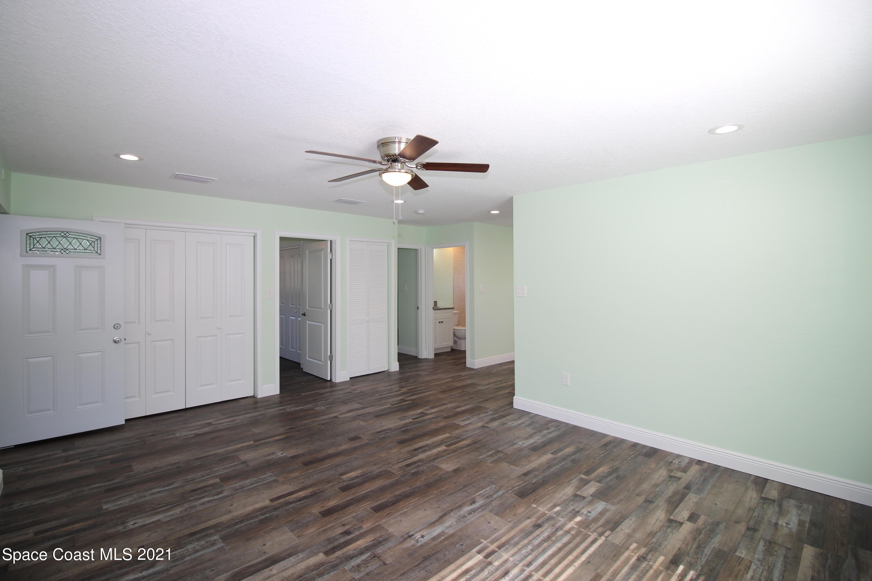244 North Grove Street Merritt Island, FL 32953 - Photo 3 of 25 a view of a room with wooden floor and a ceiling fan