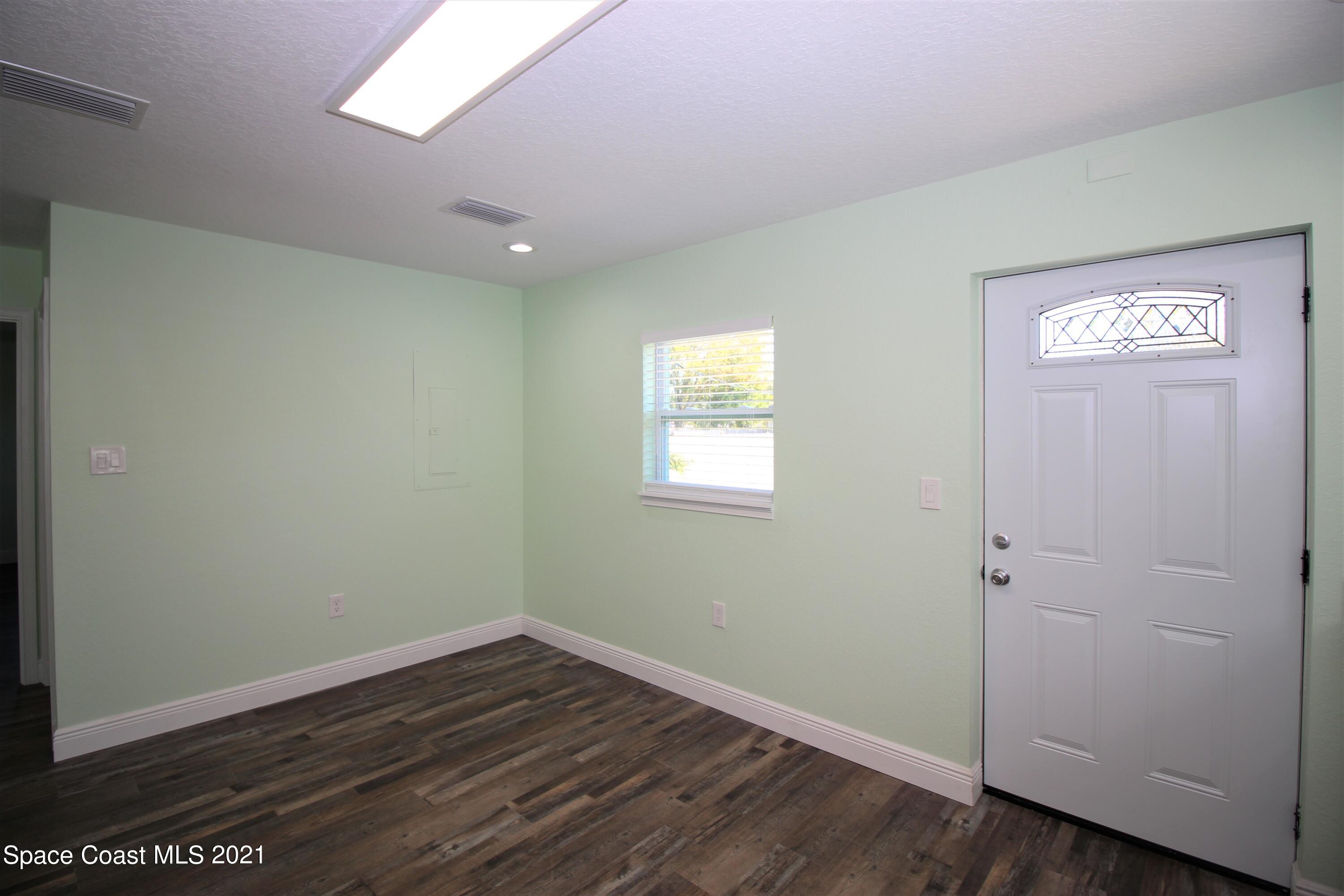 244 North Grove Street Merritt Island, FL 32953 - Photo 9 of 25 an empty room with wooden floor and windows