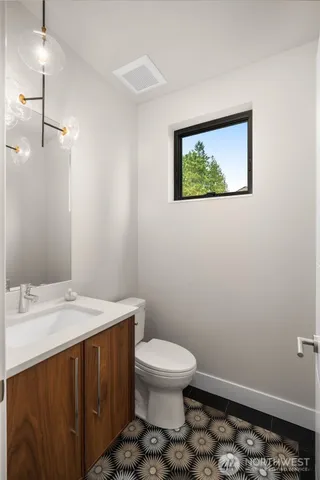 a bathroom with a toilet a sink and a mirror